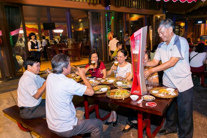 Những du khách trung niên hào hứng với các món ăn truyền thống như bánh tráng, bánh xèo... Họ vui vầy, hạnh phúc trong không gian ẩm thực đặc sắc với những món ăn truyền thống đậm đà hương vị các vùng quê.