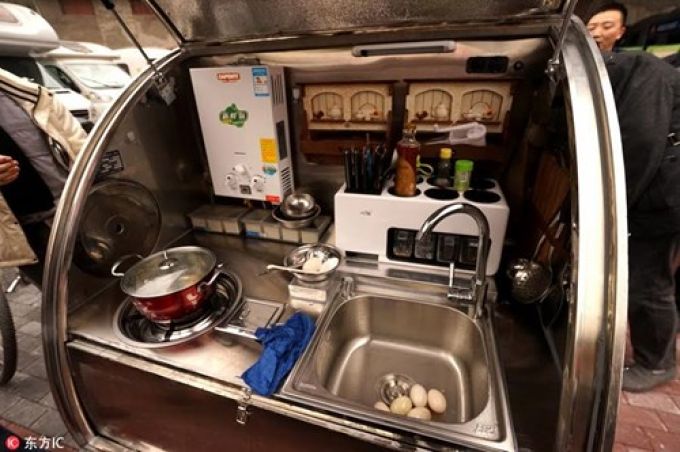 Đuôi xe được thiết kế làm phòng bếp với đầy đủ dụng cụ nấu ăn.