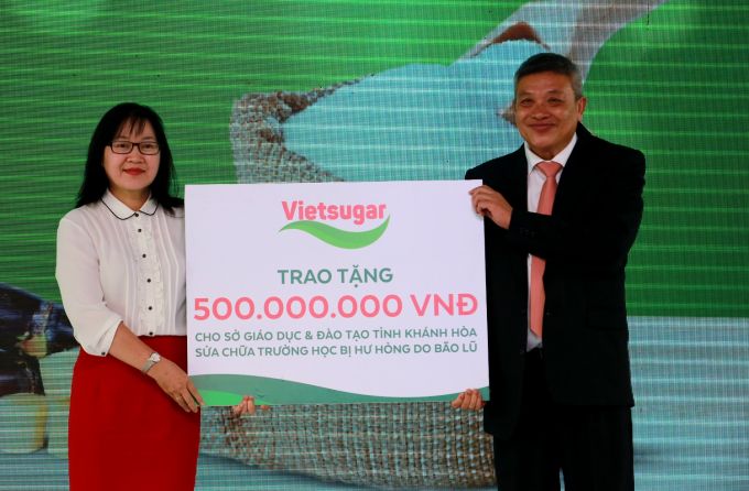 &Ocirc;ng Đỗ Th&agrave;nh Li&ecirc;m - Tổng Gi&aacute;m đốc C&ocirc;ng ty Cổ phần Đường Việt Nam đại diện trao bảng tượng trưng phần qu&agrave; 500 triệu đồng cho B&agrave; Ho&agrave;ng Thị L&yacute; &ndash; Ph&oacute; gi&aacute;m đốc Sở Gi&aacute;o Dục v&agrave; Đ&agrave;o tạo tỉnh Kh&aacute;nh H&ograve;a nhằm hỗ trợ Sở Gi&aacute;o dục v&agrave; Đ&agrave;o tạo tỉnh Kh&aacute;nh H&ograve;a sửa chữa trường học bị hư hỏng do b&atilde;o lũ.