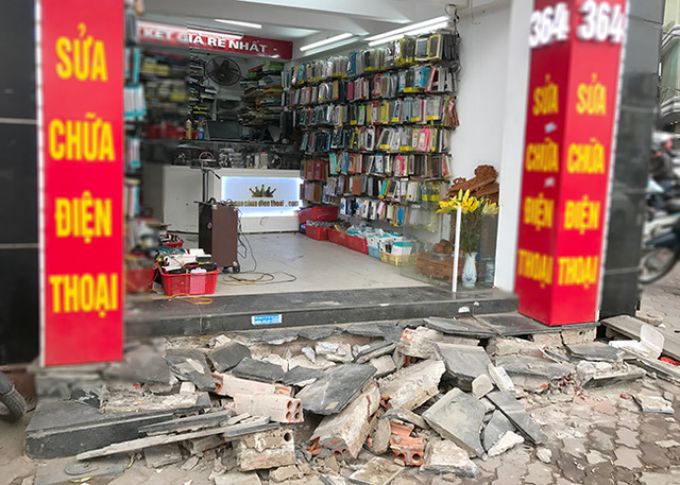 Bậc tam cấp của một cửa hàng buôn bán phụ kiện điện thoại đang cảnh ngổn ngang, chưa kịp chỉnh sửa lại.