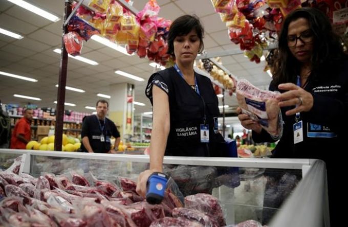 Nhân viên y tế kiểm tra tại một quầy thực phẩm ở Brazil.