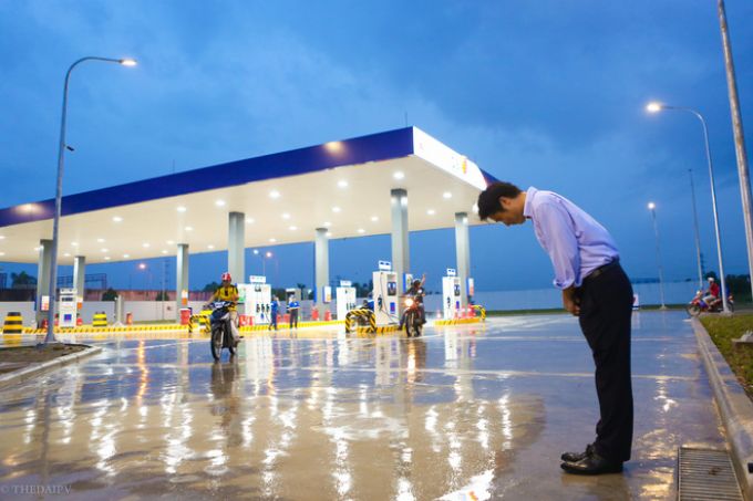 Tổng gi&aacute;m đốc Idemitsu Q8 Petroleum vẫn ki&ecirc;n tr&igrave; đứng dưới mưa, c&uacute;i gập người ch&agrave;o kh&aacute;ch đến đổ xăng.
